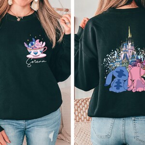a woman wearing a black sweatshirt with a castle on it