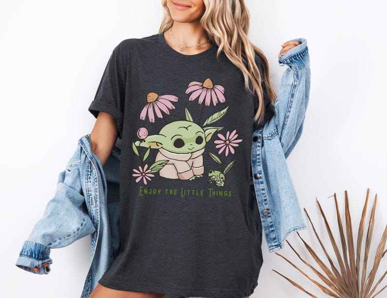 a woman wearing a black shirt with a baby yoda on it