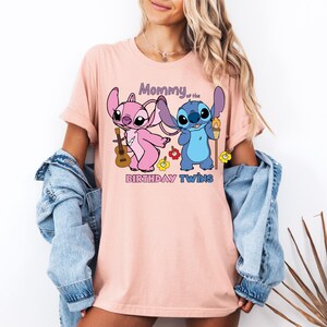 a woman wearing a pink t - shirt with cartoon characters on it