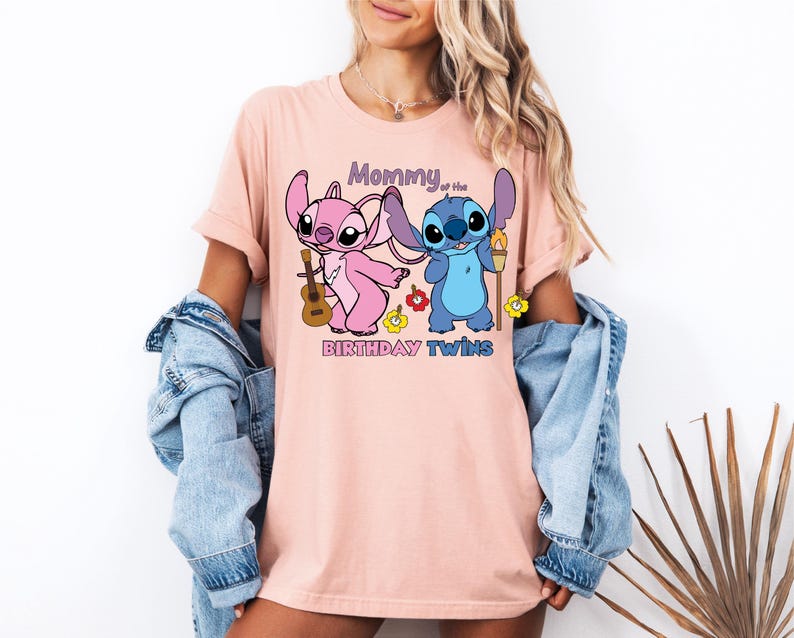 a woman wearing a pink t - shirt with cartoon characters on it