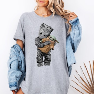 a woman wearing a t - shirt with a baby groote on it