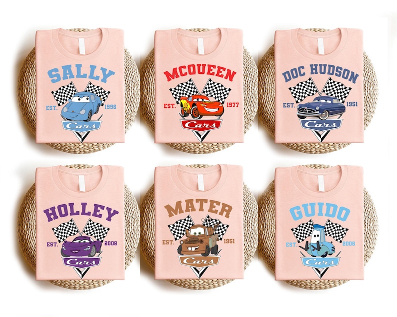 a set of four pink bibs with cars on them