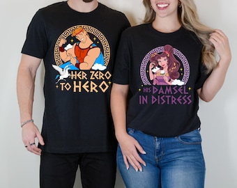 Puede incluir: Dos camisetas negras con un estampado gráfico de personajes de la película de Disney Hércules. La camiseta de la izquierda tiene un gráfico de Hércules con el texto "Her Zero to Hero". La camiseta de la derecha tiene un gráfico de Megara con el texto "His Damsel in Distress".