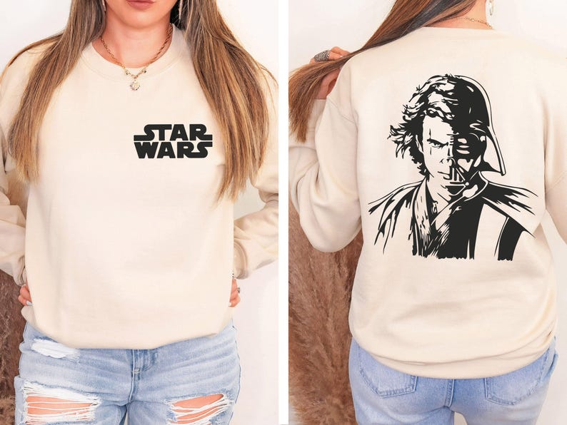 a woman wearing a star wars sweatshirt and ripped jeans