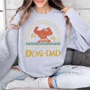 a woman sitting on a couch wearing a sweatshirt
