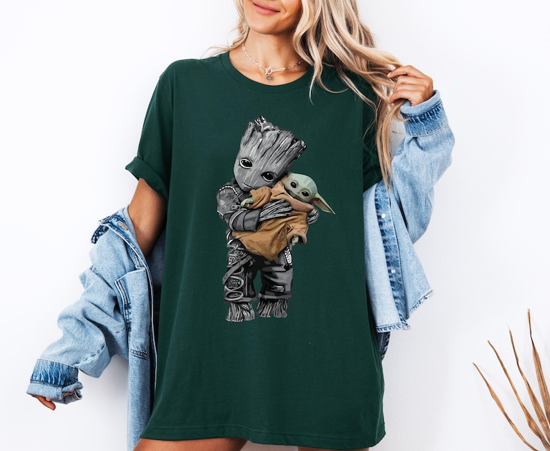 a woman in a green shirt holding a baby groote