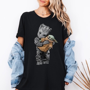 a woman wearing a black shirt with a baby groote on it