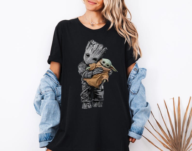 a woman wearing a black shirt with a baby groote on it