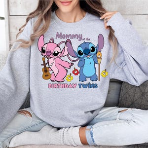 a woman sitting on a couch wearing a sweatshirt