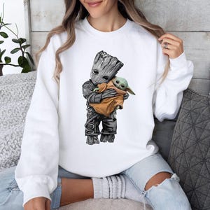 a woman sitting on a couch holding a baby groote shirt