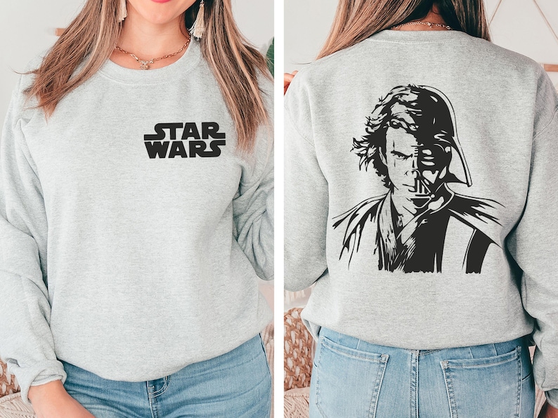 a woman wearing a star wars sweatshirt and jeans
