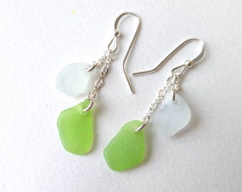 May include: A pair of silver dangle earrings with two sea glass charms. One charm is light green and the other is light blue.