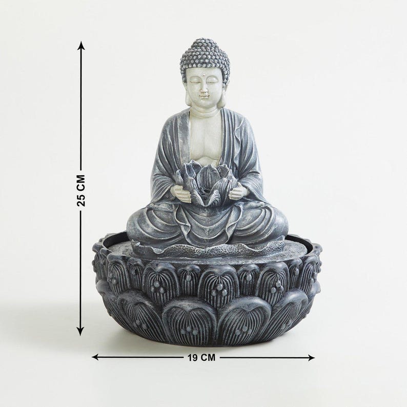 May include: A gray Buddha statue, 25 cm tall and 19 cm wide, seated in a lotus position, holding a lotus flower. The statue is atop a lotus-shaped base, creating a serene and spiritual ambiance. Ideal for home decor.