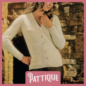May include: A white knitted cardigan with a V-neck and button closure. The cardigan has a textured knit pattern and is shown being worn by a model.