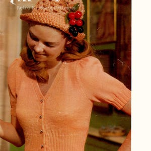 May include: A vintage-style image featuring a woman wearing a peach-colored knitted hat with berry accents and a matching short-sleeved cardigan. The text "Pattique Retro Knitting Patterns" is visible.