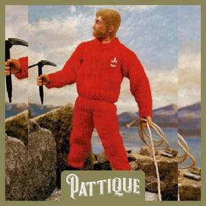 Puede incluir: Un conjunto de suéter y pantalón de punto rojo con un logotipo blanco en el pecho. La figura sostiene una cuerda y un piolet.