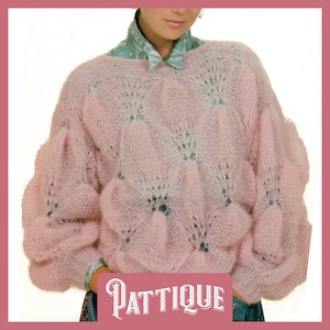 May include: A pink knitted sweater with a lacy pattern and a wide, round neckline. The sweater has a loose fit and long sleeves.