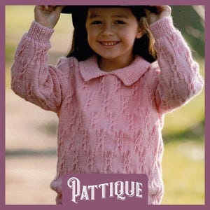 Könnte beinhalten: Ein rosa gestrickter Pullover mit einem Zopfmuster und einem Kragen. Der Pullover wird von einem Kind getragen und trägt den Schriftzug "PATTIQUE" am unteren Rand.