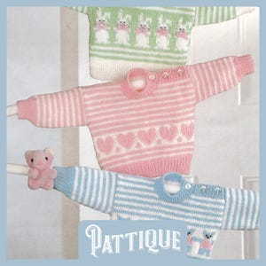 Peut inclure: Trois pulls en tricot pour bébé, un vert avec des lapins blancs, un rose avec des rayures blanches et des cœurs roses, et un bleu avec des rayures blanches. Les pulls sont suspendus à une corde à linge.