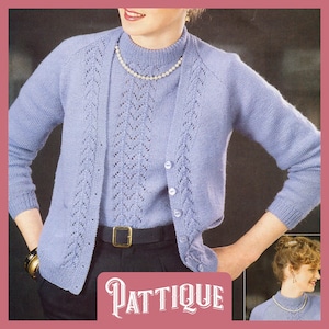May include: A light blue knitted cardigan with a matching top, featuring a delicate lace pattern. The cardigan has a button closure and the top has a high neckline. The model is wearing a pearl necklace and a black belt.