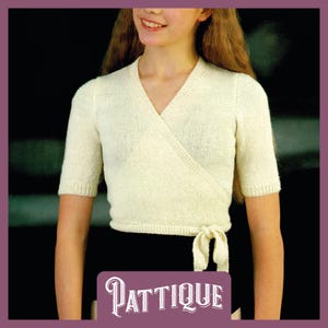 May include: A white wrap-style knitted top with short sleeves and a tie at the waist. The top is made of a soft, lightweight yarn and has a relaxed fit.