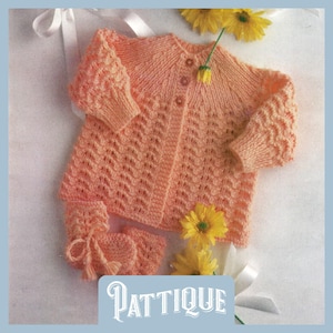 May include: A peach-coloured knitted baby cardigan and matching booties with a delicate openwork pattern. The cardigan has a button fastening and the booties have a tie fastening.