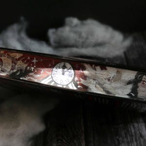 May include: A close-up of a book cover with a red, white and blue design. The cover features a clock face, stars and a figure with wings. The text "Time" is visible on the cover.