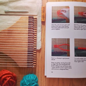 May include: A wooden weaving loom with white warp threads, a small green tool, and a beige fabric. The image also shows a page from a book with instructions and close-up photos of weaving techniques, along with two balls of yarn.