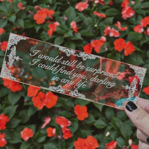 Könnte beinhalten: Ein transparentes Acryl-Lesezeichen mit einem dekorativen Rand und dem Text "I would still be surprised I could find you, darling in any life".