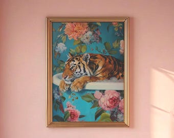 May include: A framed artwork depicts a tiger resting in a bathtub, set against a floral background. The artwork features a gold frame and is displayed in a pink-toned bathroom. The tiger's fur is orange and black.