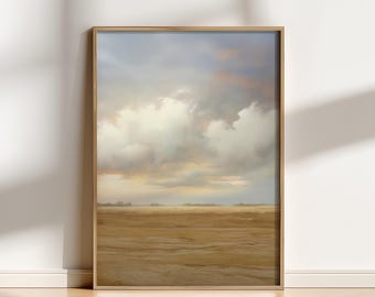 May include: A framed landscape art print featuring a serene scene of a field under a cloudy sky. The artwork has a natural wood frame and depicts a field in shades of tan and brown, with a sky of white, blue, and peach hues.