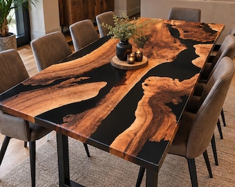 Puede incluir: Una mesa de comedor rectangular con un tablero de madera de borde natural y una incrustación de resina negra, sostenida por una base de metal negro en forma de U, acompañada de ocho sillas grises tapizadas con patas negras.