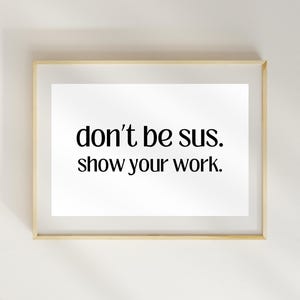 Peut inclure: Une impression encadr&eacute;e avec le texte "don't be sus. show your work." en police noire sur fond blanc.