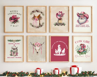 May include: A set of eight framed wall art prints featuring Western-themed Christmas illustrations, including cowboy hats, boots, a saddle, a cow skull with flowers, and Santa, all displayed in a grid arrangement on a light wall.