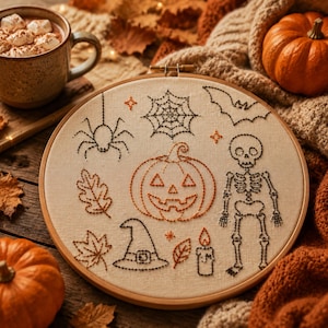 Puede incluir: Un bastidor de bordado circular de madera con tela color hueso que presenta motivos de Halloween bordados en negro y naranja, incluyendo una araña, telaraña, murciélago, calabaza, esqueleto, sombrero de bruja, vela y hojas de otoño.