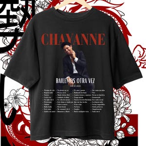 以下が含まれることがあります： 白い歌手チャヤンヌの画像、テキスト「Bailamos Otra Vez Tour 2023」、そして曲名のリストが書かれた黒いTシャツ。