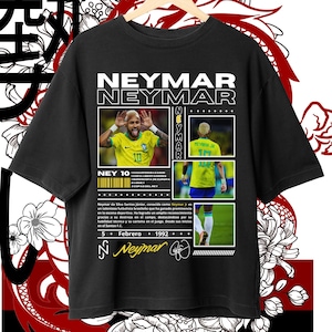 Op de afbeelding: Zwart T-shirt met een grafisch ontwerp met een foto van voetballer Neymar Jr. Het ontwerp bevat de tekst "Neymar Neymar" in witte letters, een foto van Neymar Jr. in een voetbaltenue en de tekst "Ney 10" in een geel vak. De tekst "5 Febrero 1992" en een handtekening zijn ook in het ontwerp opgenomen.