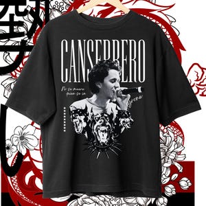 Pode incluir: T-shirt preto com um gráfico a preto e branco de um cantor e o texto "CANSERBERO". Abaixo da imagem estão três cabeças de cão. A camisa tem o texto "No se muere quien se in" e "Tyrone".
