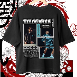 以下が含まれることがあります： 「TITO DOUBLE P」の文字と男性の画像がプリントされた黒いTシャツ。テキストと画像を使ったグラフィックデザインで、背景には花柄とドラゴンのデザインが施されています。