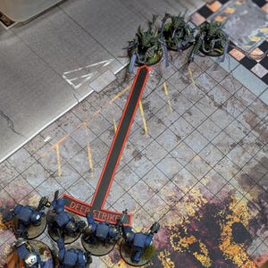 May include: A tabletop game scene with miniature figures. Three green and purple insect-like creatures face six blue armored figures. A red and black marker with the words "DEEP STRIKE" is positioned between the two groups.