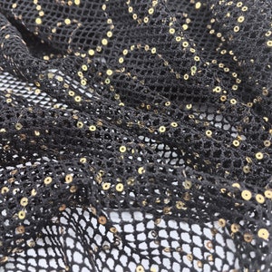 May include: Black mesh fabric with gold sequins. The fabric has a diamond pattern.