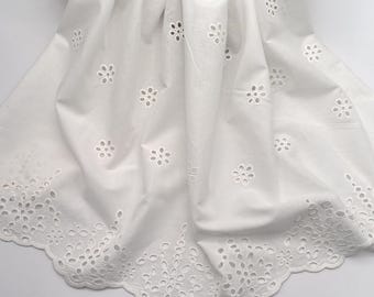 May include: White cotton fabric with a scalloped edge and a delicate floral eyelet pattern.