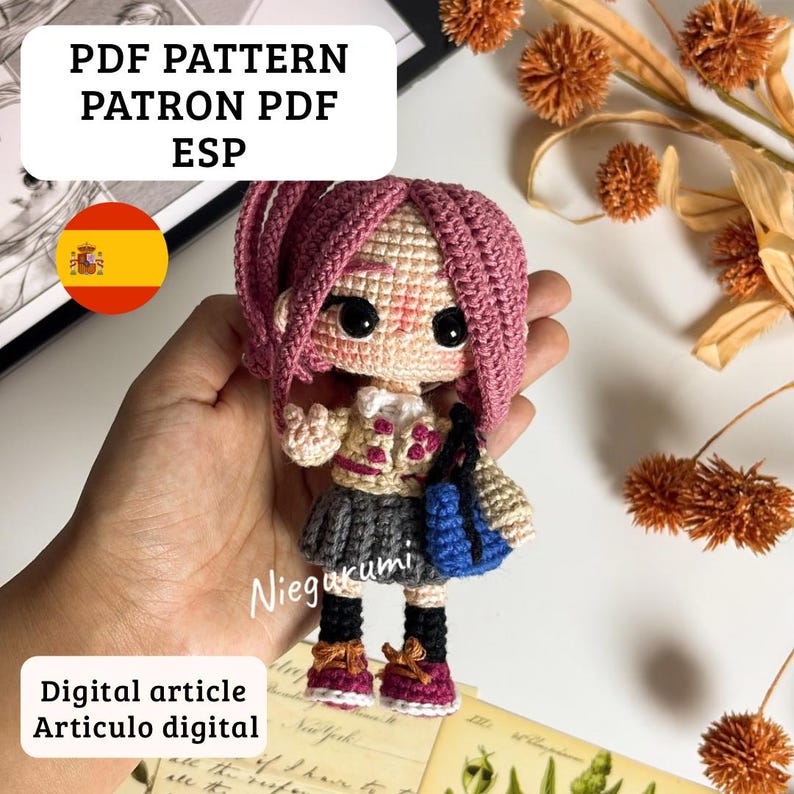 May include: A crocheted doll with pink hair, a gray skirt, and a blue bag. The doll is holding a small blue bag and wearing a cream-colored jacket. Text on the image reads "PDF PATTERN PATRON PDF ESP" and "Digital article Articulo digital."