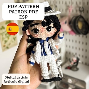 May include: A crocheted doll wearing a white suit with blue accents, a black hat, and black hair. The doll is holding a pose. Text on the image reads "PDF PATTERN PATRON PDF ESP" and "Digital article Articulo digital".
