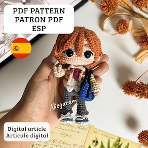 Puede incluir: Muñeca de ganchillo hecha a mano con cabello naranja, que lleva una chaqueta, camisa y pantalones grises. La muñeca tiene una mochila azul y zapatillas azules. El texto en la imagen dice "PDF PATTERN PATRON PDF ESP" y "Digital article Articulo digital".