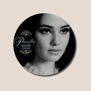 May include: Black and white circular graphic featuring a woman's portrait. The text "Priscilla" is displayed in a stylized font, with additional text reading "YOU'RE LOSING ME TO A LIFE OF MY OWN" and "SOFIA COPPOLA".