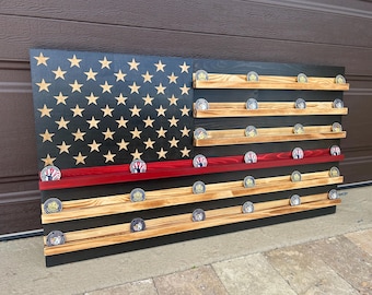 May include: Wooden American flag-themed display case with a black background and gold stars. Features multiple shelves to hold challenge coins. A red stripe is present, and the flag is made of wood.