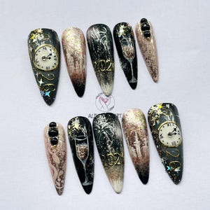 May include: A set of ten artificial nails with a New Year's Eve theme. Designs include clocks, fireworks, champagne glasses, and the year 2022 in gold. The nails feature a variety of colors, including black, gold, and pink.