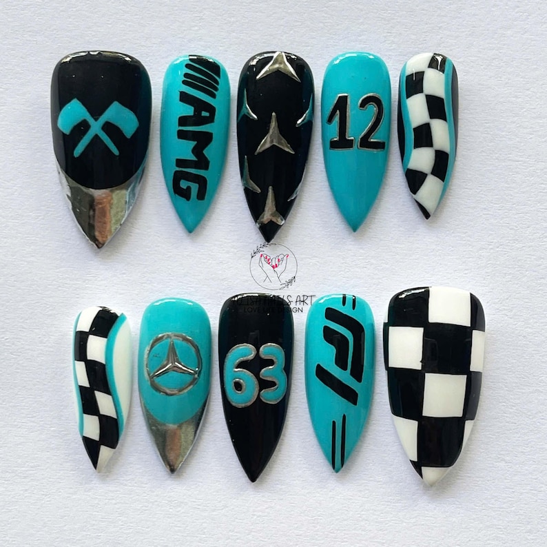 May include: A set of ten artificial nails with a racing theme. The nails feature designs in black, teal, and silver, including racing flags, the AMG logo, the number 12, a checkered flag pattern, the Mercedes logo, the number 63, and the F1 logo.