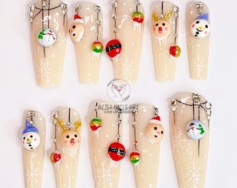 Pode incluir: Dez unhas postiças compridas bege com designs natalinos. Cada unha apresenta um design diferente, incluindo um boneco de neve, uma rena, Papai Noel e enfeites de Natal.